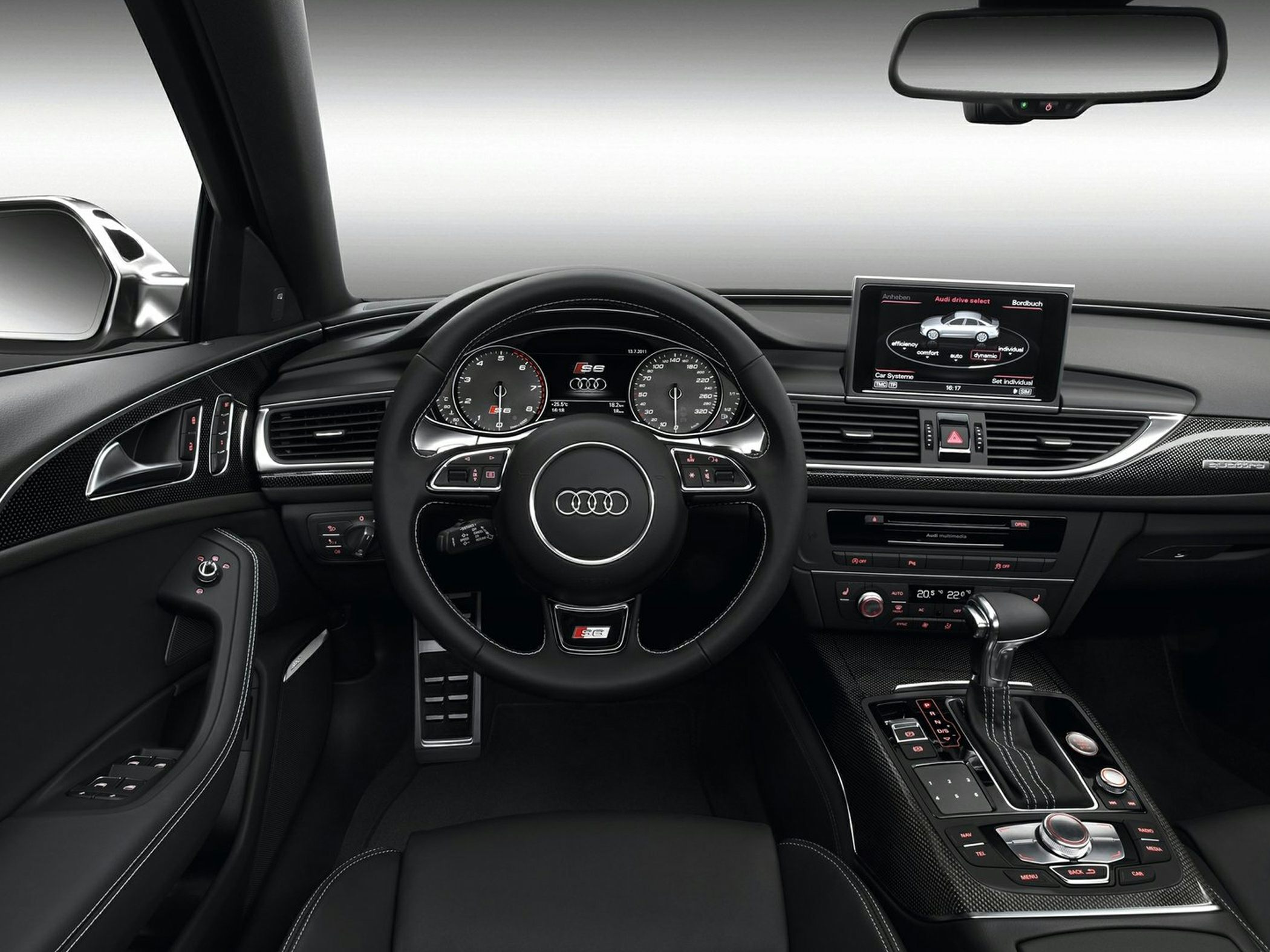 Modern dashboard and steering wheel with multimedia screen and carbon fiber trim