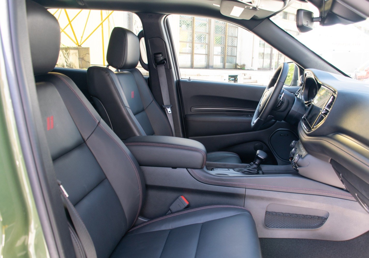 Black leather seats with red stitching, modern dashboard and center console