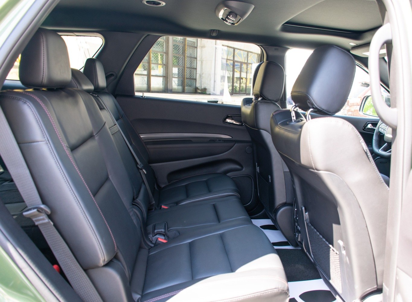 Spacious black leather rear passenger seats with seat belts and headrests