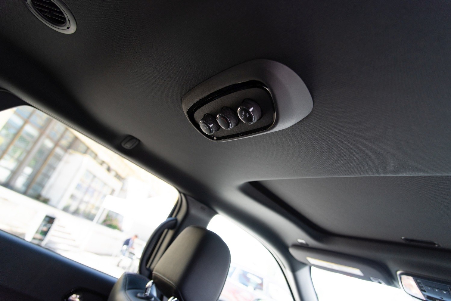 Overhead climate control knobs and ceiling air vent in vehicle interior