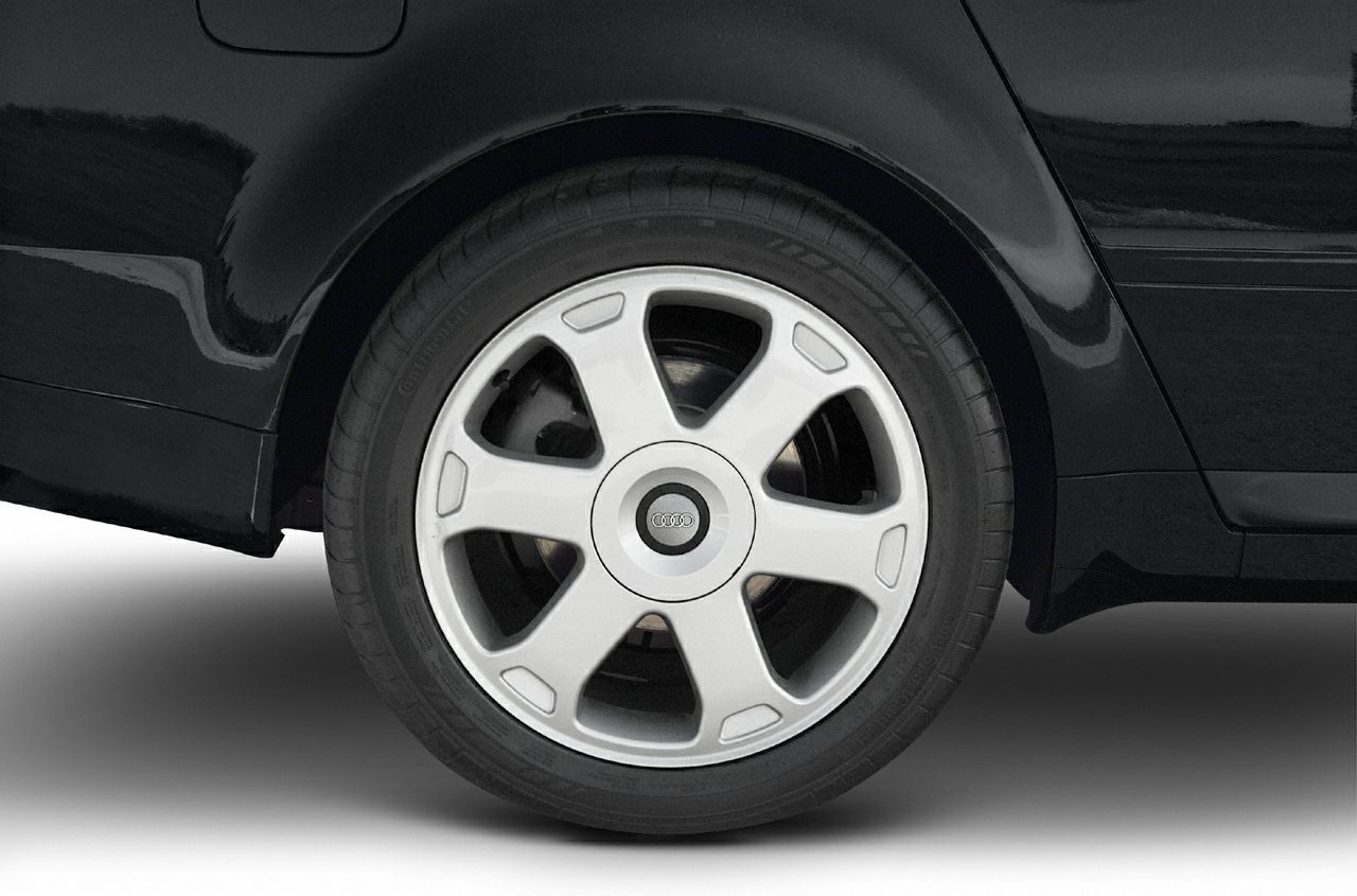 Close-up of alloy wheel with multi-spoke rim on black painted car body.