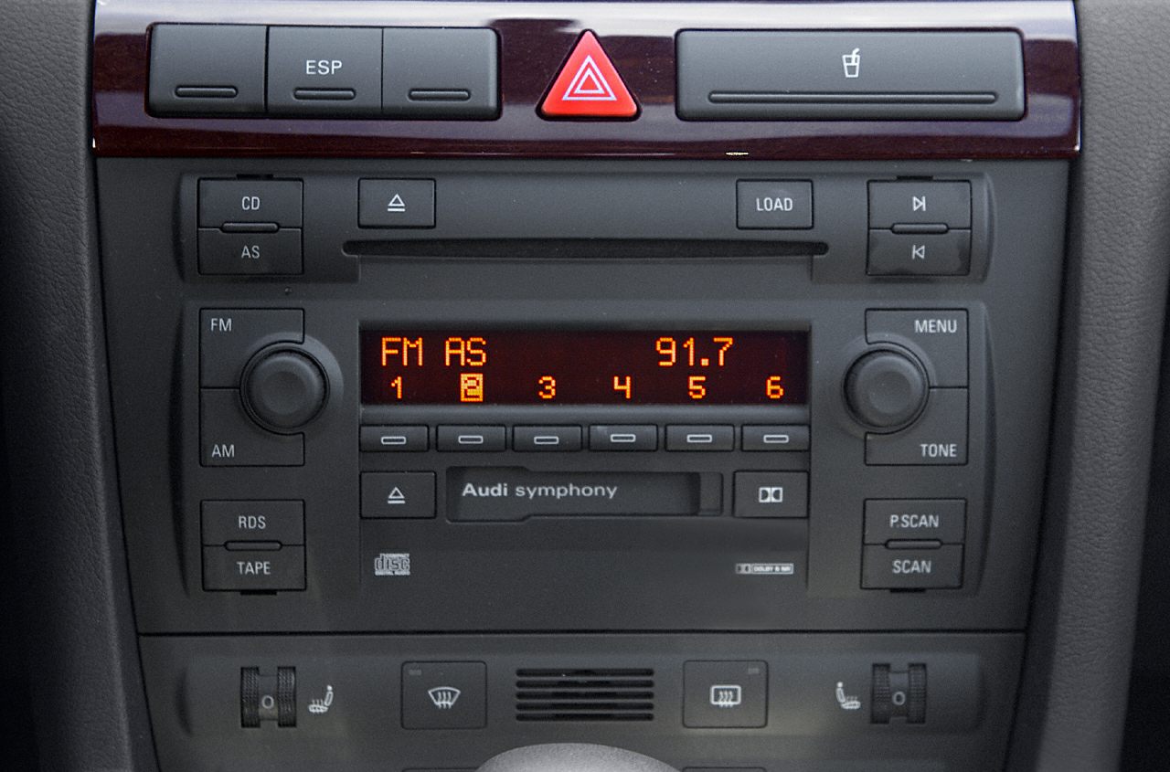 Car stereo and climate control panel with buttons and digital display