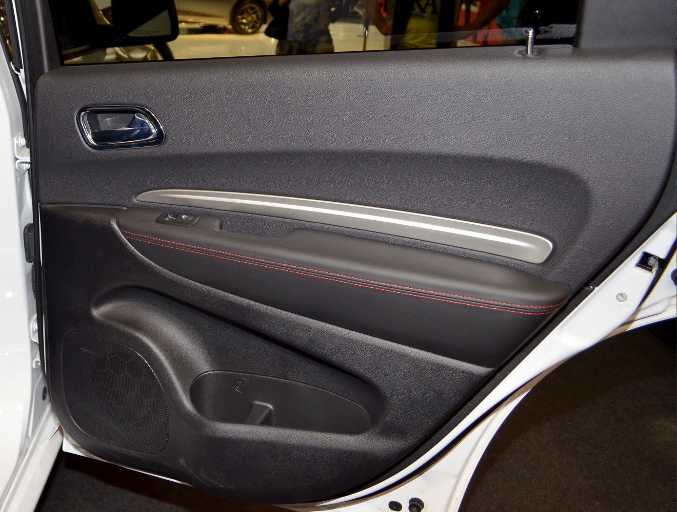 Interior door panel with silver trim and red stitching