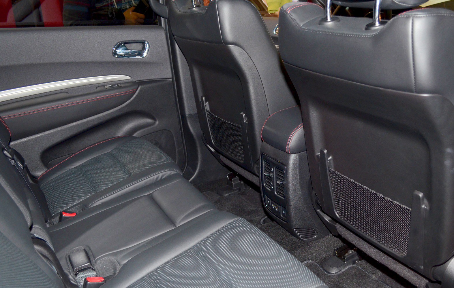 Rear seat interior with air vents and seat back storage nets.