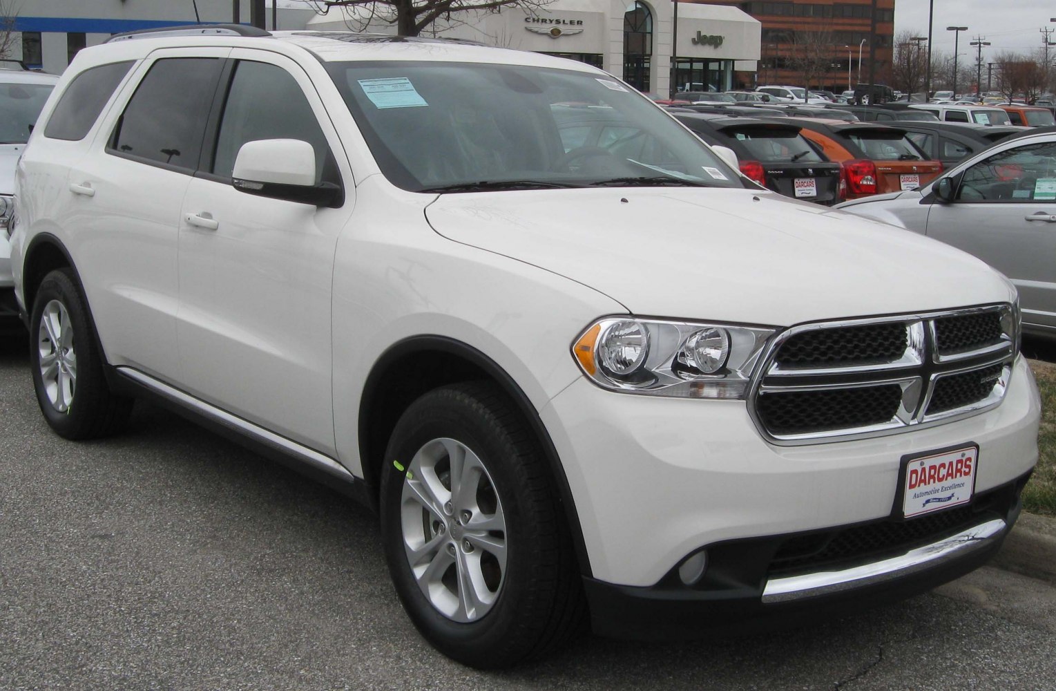 White mid-size SUV with bold front grille and 5-spoke alloy wheels