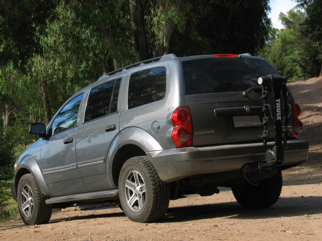 Rear side view of an SUV with roof rails and a bike rack.