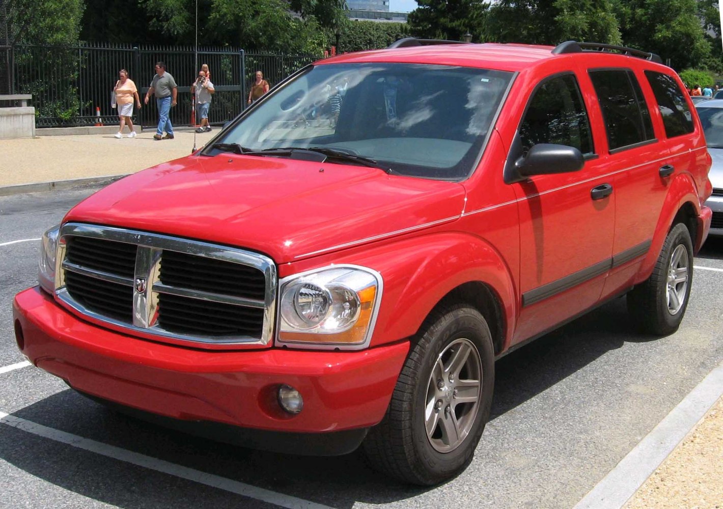 Red SUV with prominent grille and headlights, roof rails, alloy wheels