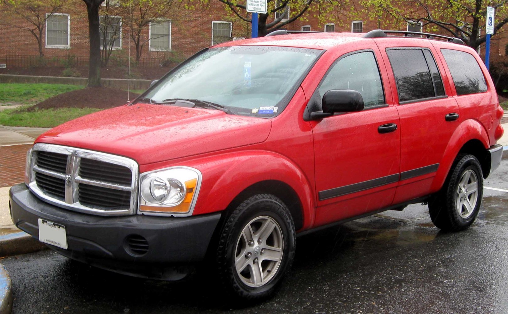 Red SUV with chrome grille and roof rack in rainy conditions