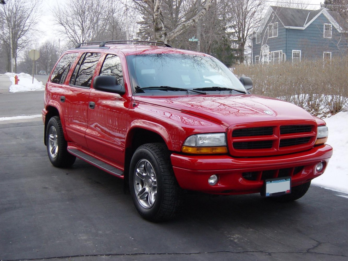 Bold front grille, chrome wheels, side steps on a red SUV