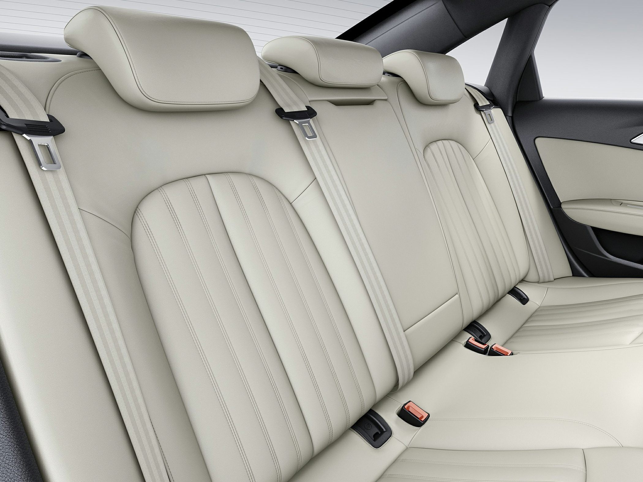 Beige leather rear seats with stitching and integrated headrests