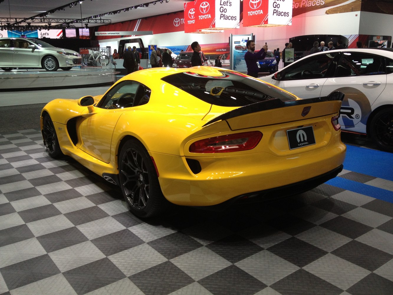 Rear view of yellow sports coupe with aerodynamic spoiler and sleek taillights