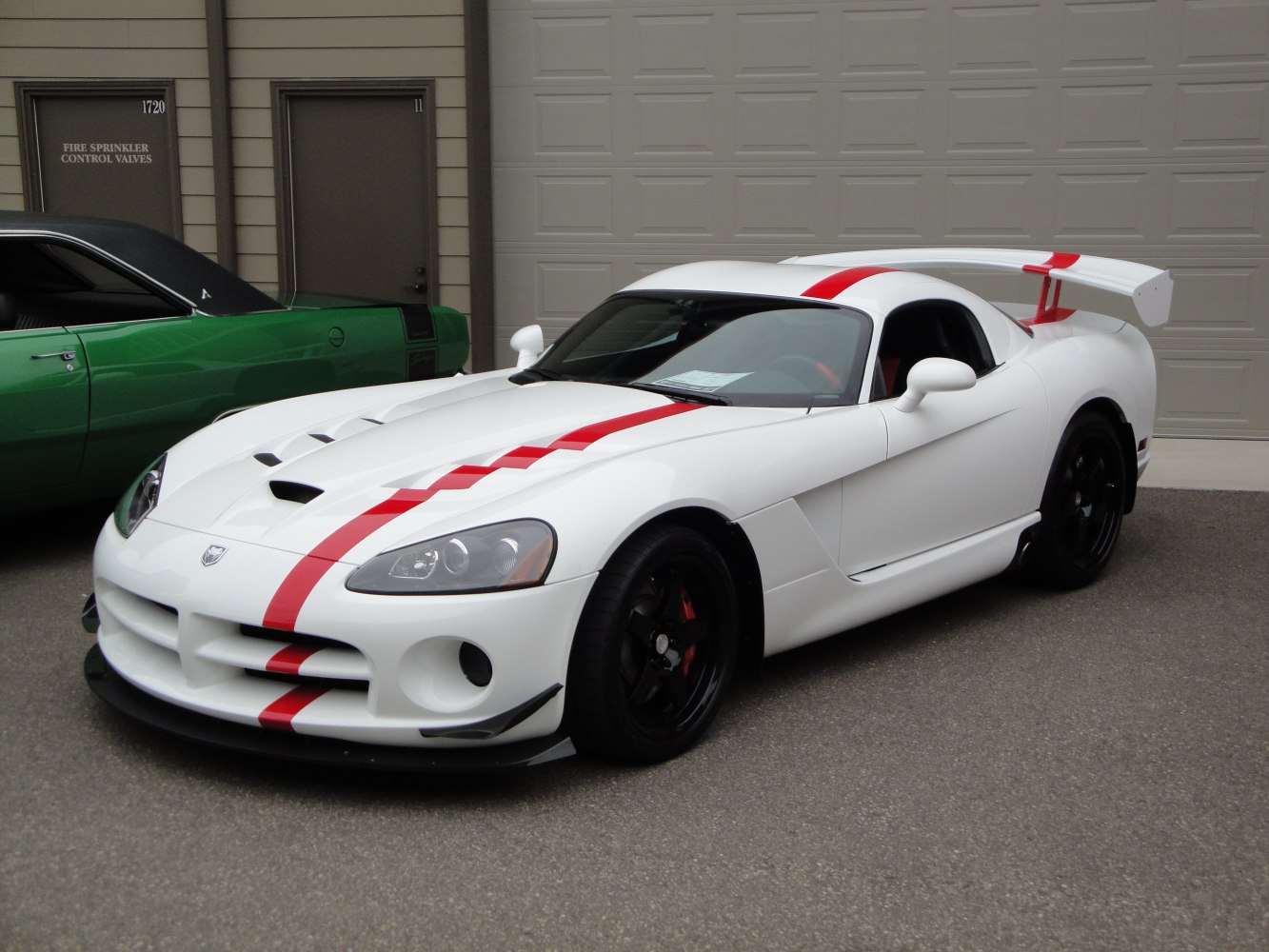 White sports car with red racing stripe and large rear wing