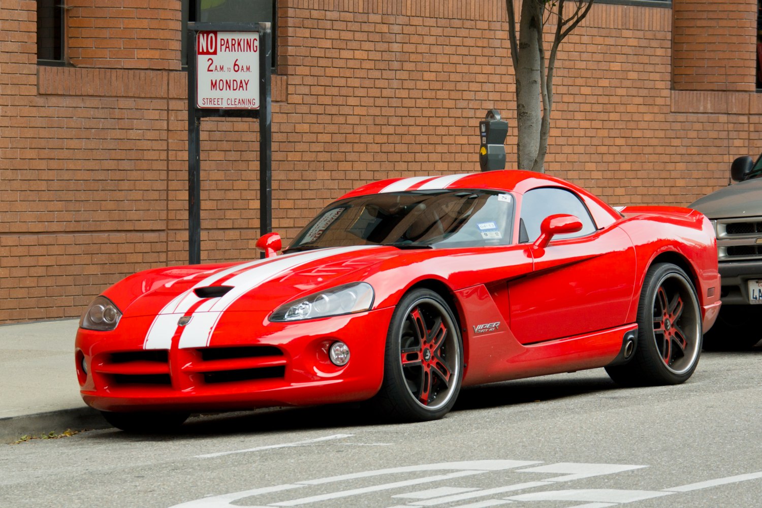 Red sports coupe with white racing stripes and distinctive Viper styling