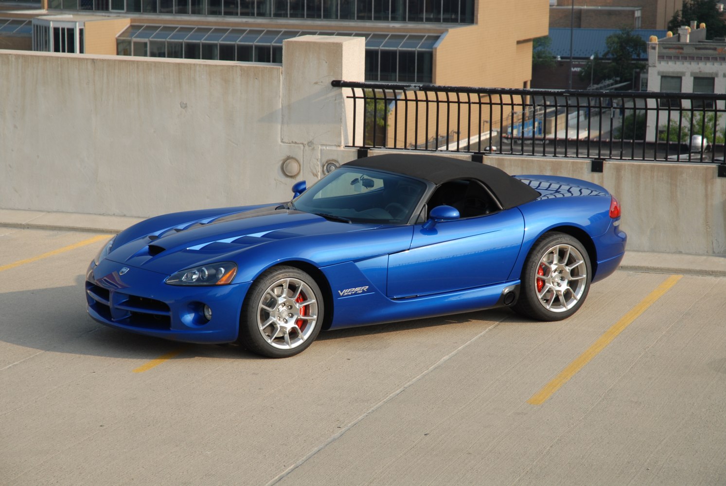 Blue convertible sports car with hood vents and alloy wheels