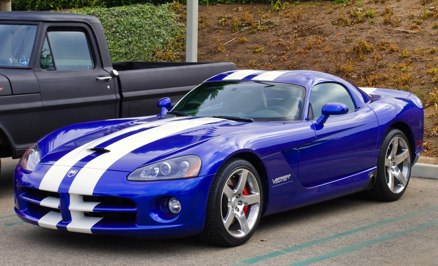 Blue sports coupe with white racing stripes and alloy wheels