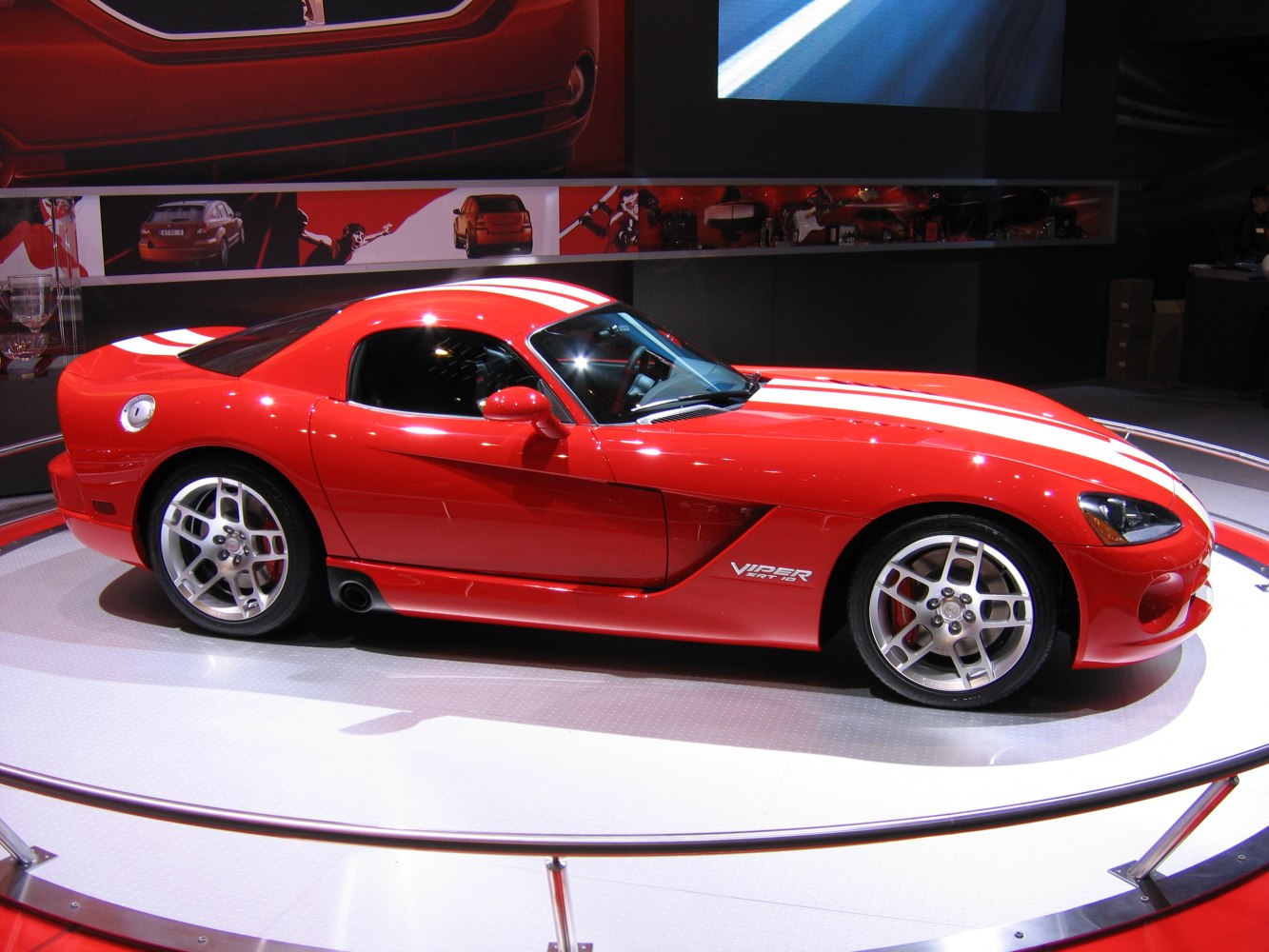 Red coupe with white racing stripes and alloy wheels