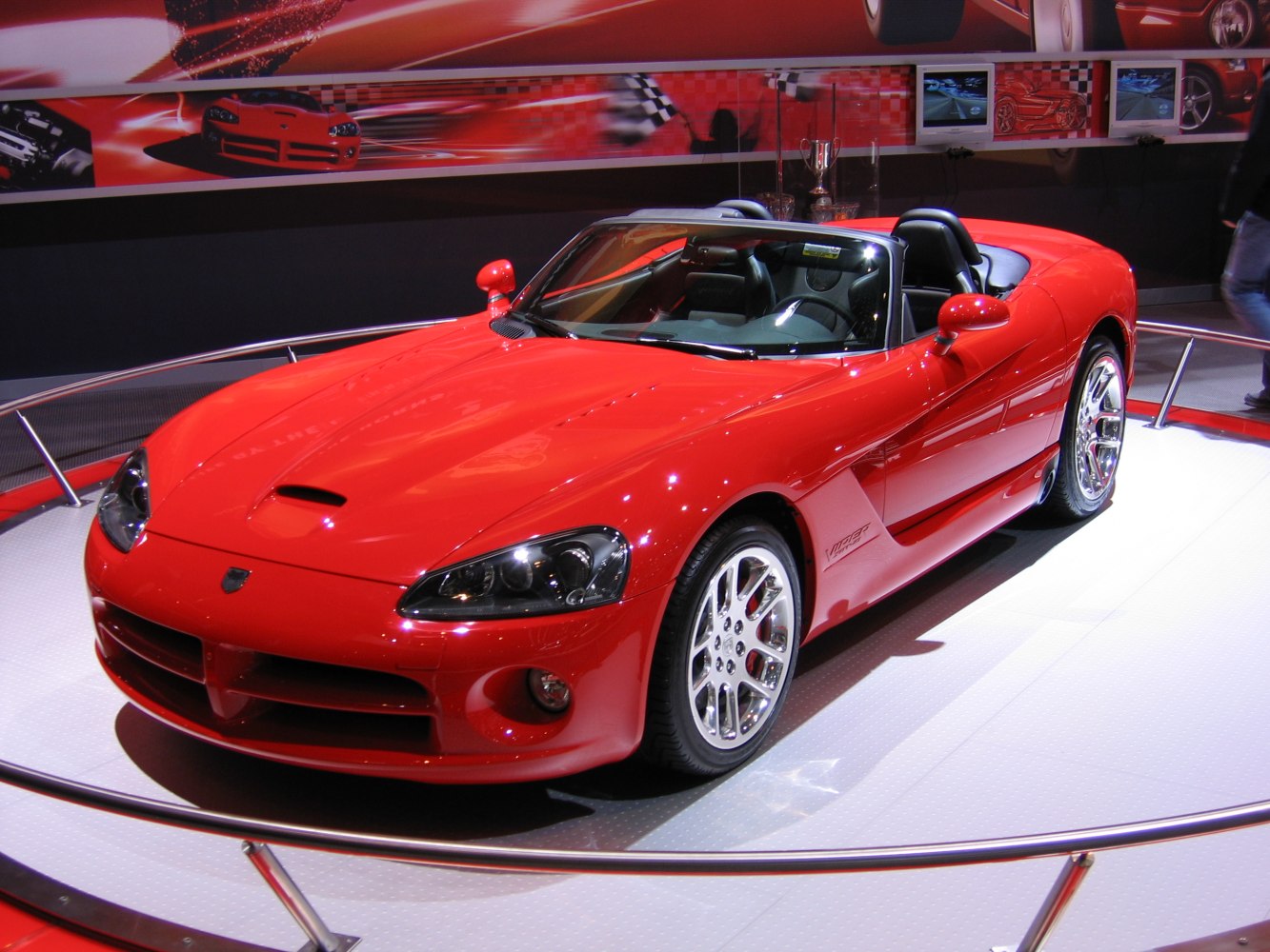 Red sports convertible with aggressive front design and polished alloy wheels