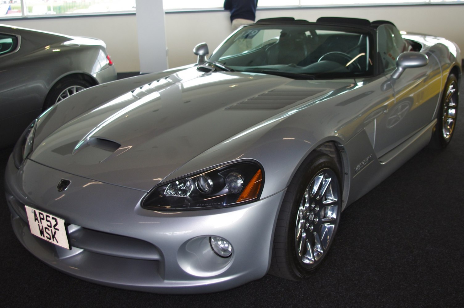 Silver convertible sports car with aggressive front and chrome wheels