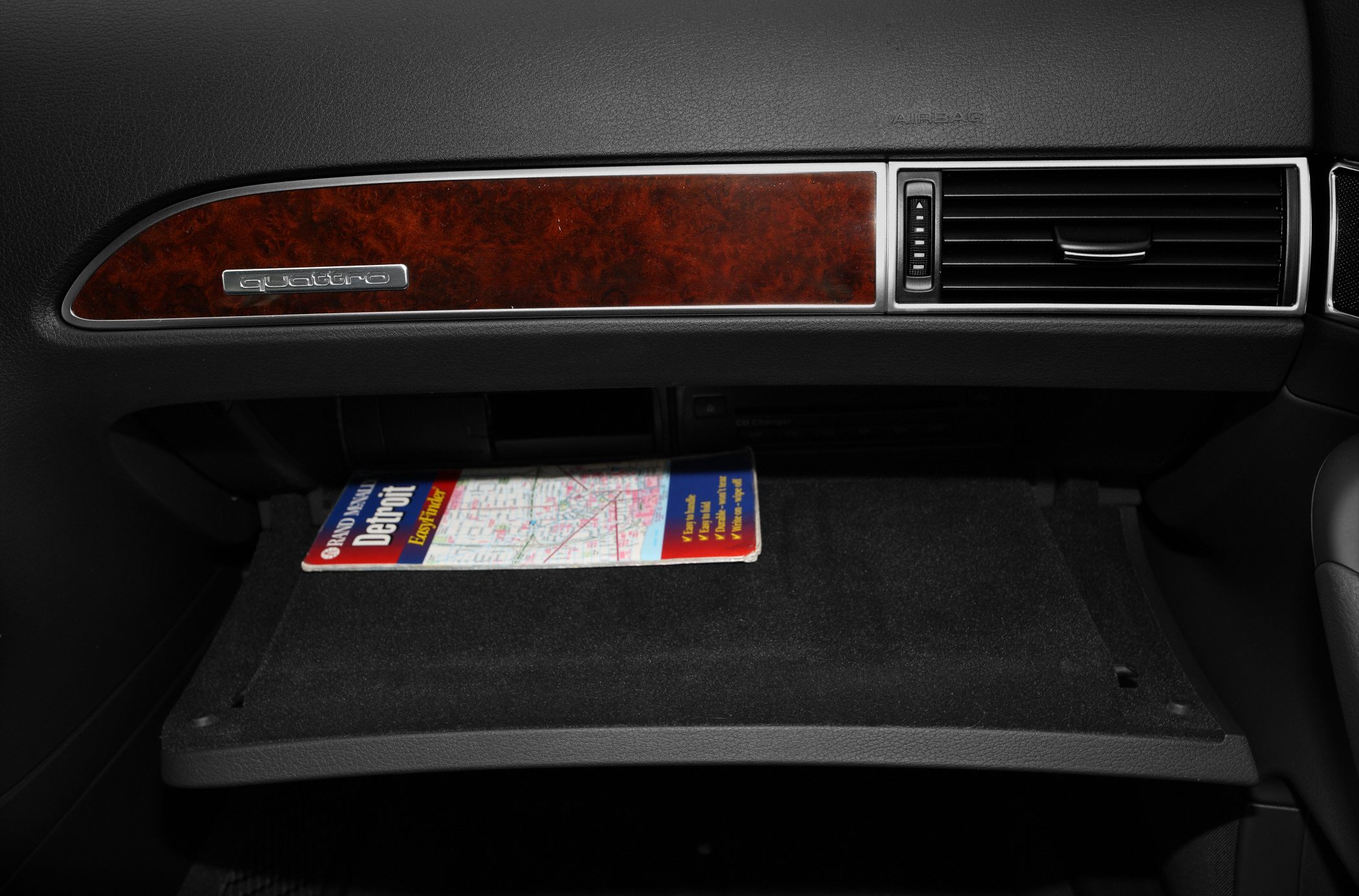 Glovebox with map and Quattro badge on wood dashboard trim