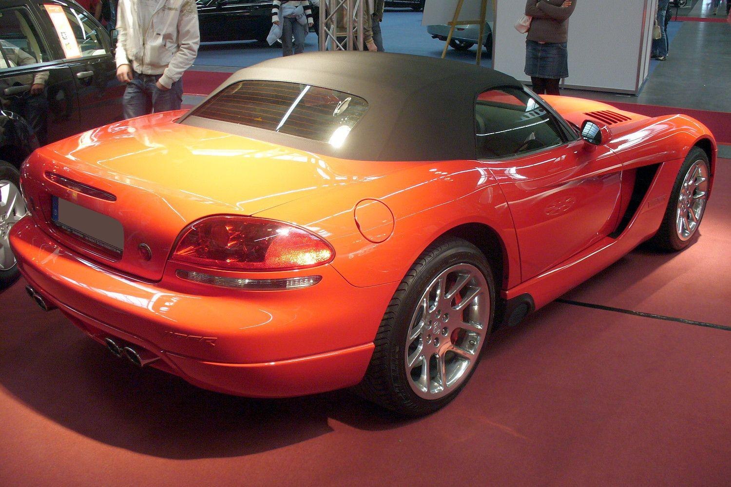 Rear and side view of orange convertible with soft top and distinctive taillights