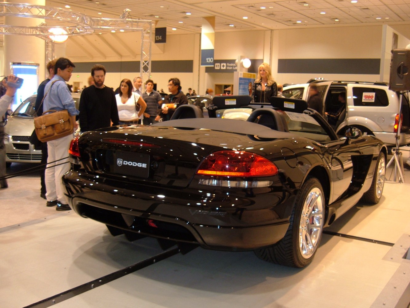 Convertible sports car's rear with open roof and chrome wheels