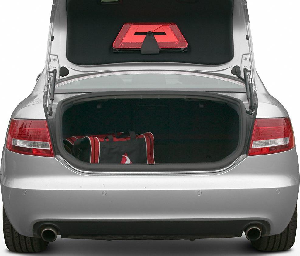 Open car trunk with emergency warning triangle and red/black duffel bag.