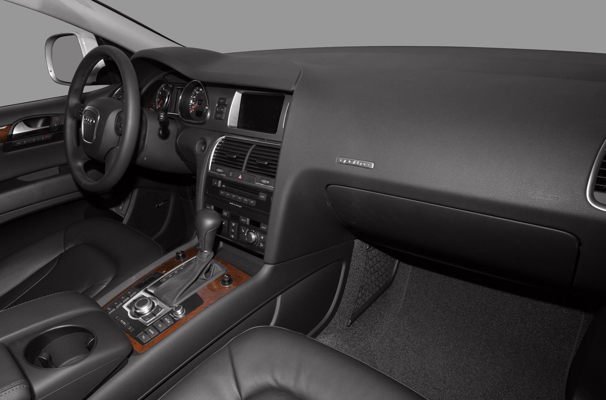 Modern dashboard with wood trim, automatic gear shifter, steering wheel and infotainment controls