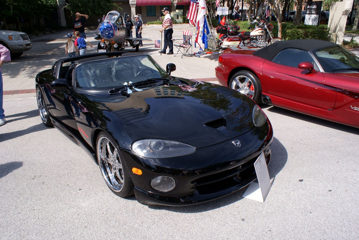 Front view of black convertible with chrome wheels and hood scoop