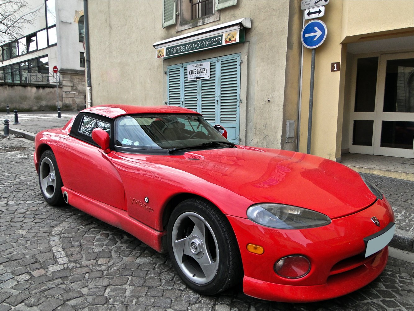 Sleek red sports coupe with aerodynamic front and side exhausts.
