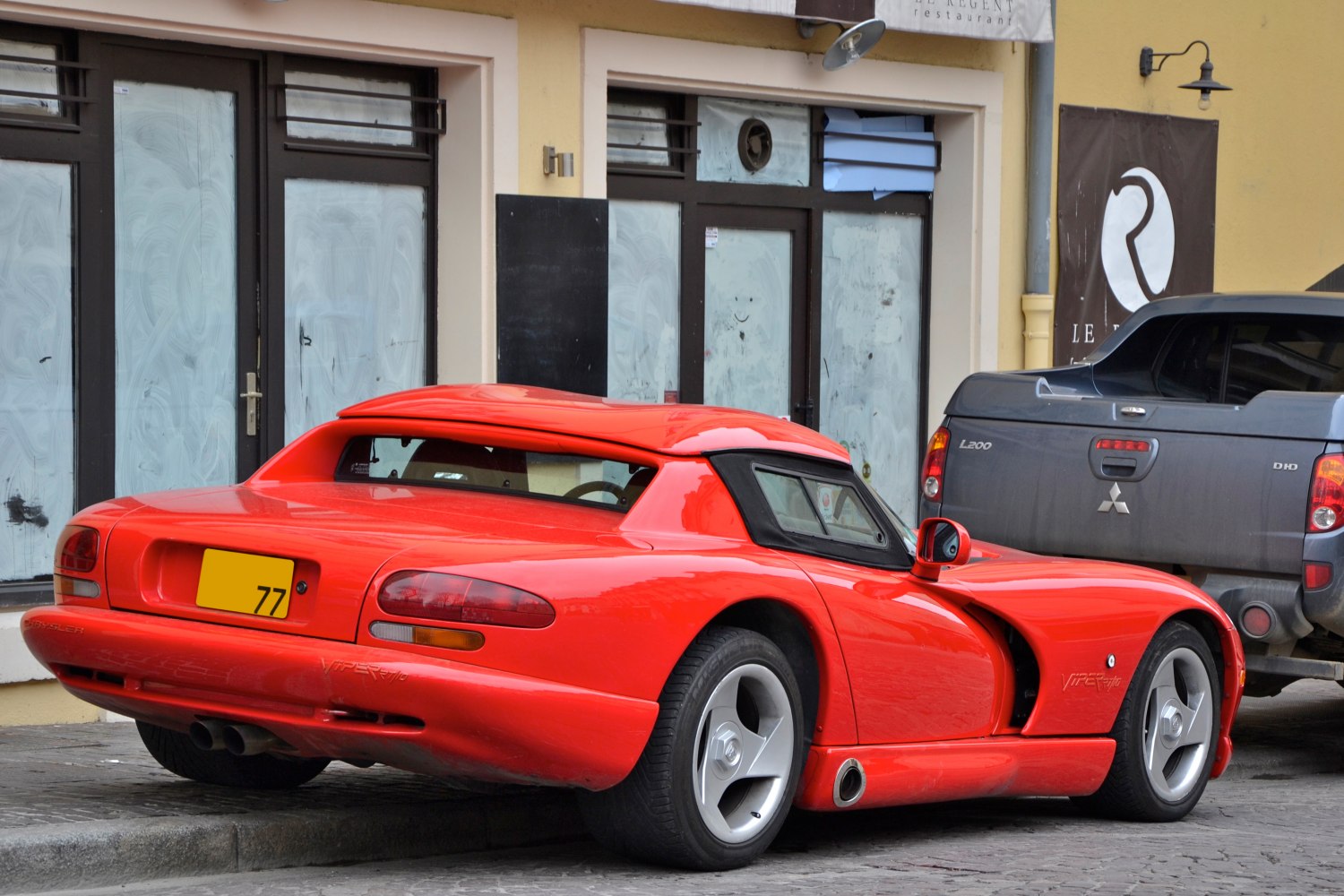 Red sports coupe with side exhaust and wide rear tires