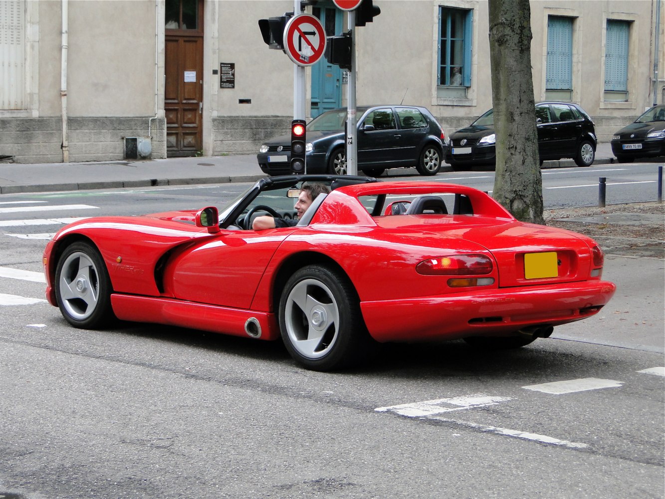 Red convertible sports coupe with side exhaust and aerodynamic curves
