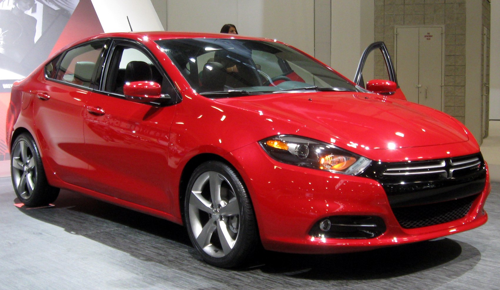 Red sedan with alloy wheels and LED headlights.