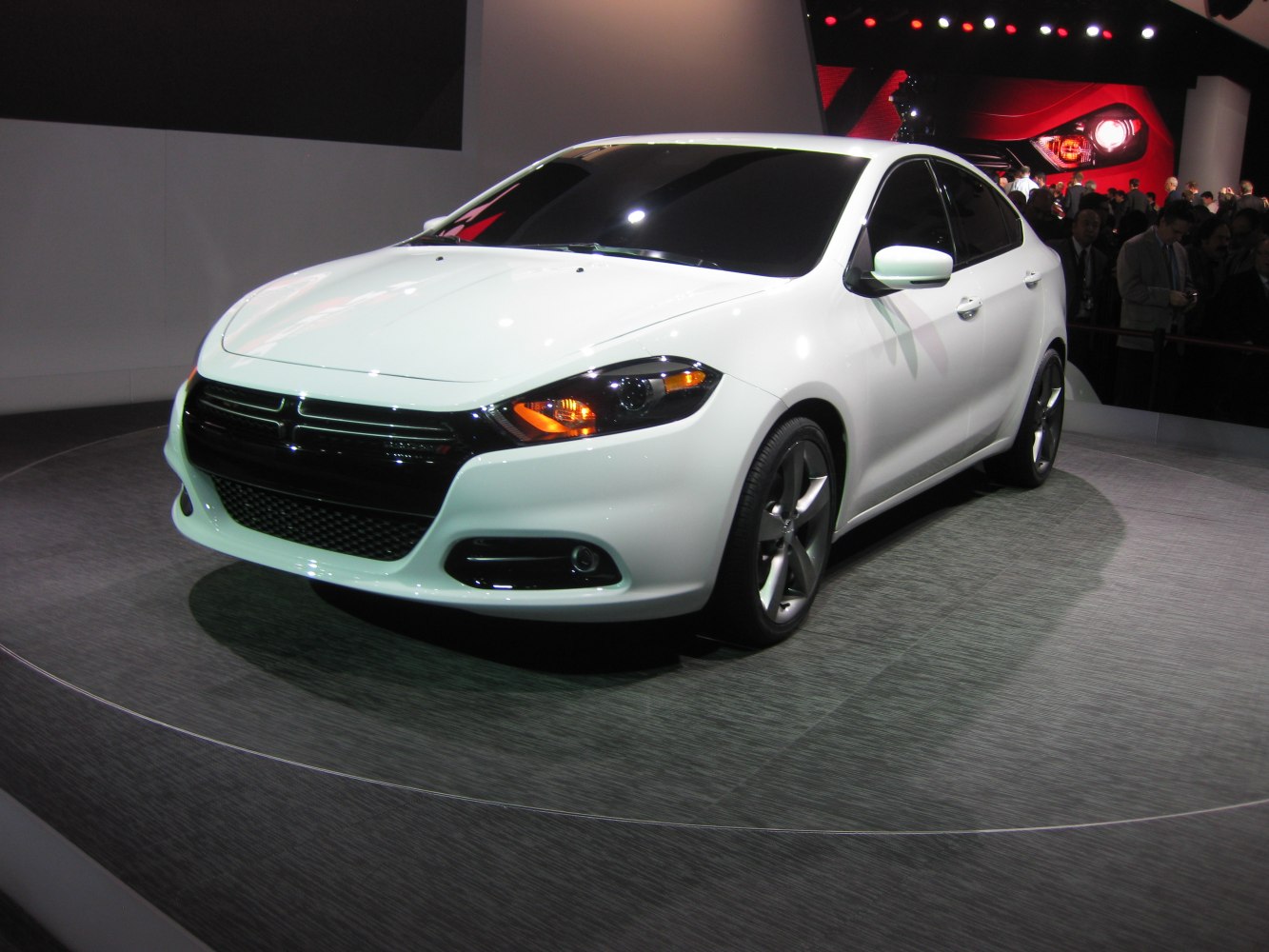 White sedan with black grille, fog lights, and alloy wheels