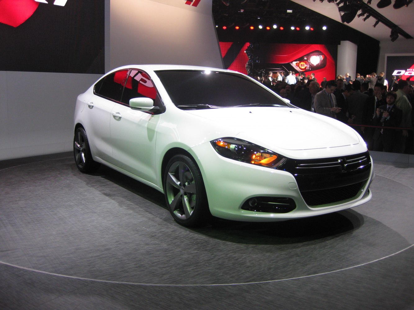 Sleek white mid-size sedan with modern headlights and alloy wheels