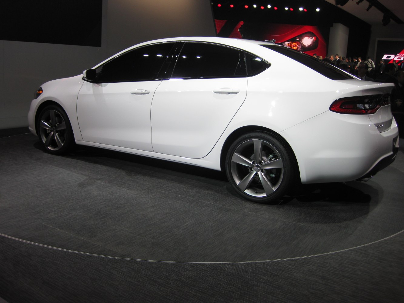 Side profile of white sedan with alloy wheels and tinted windows