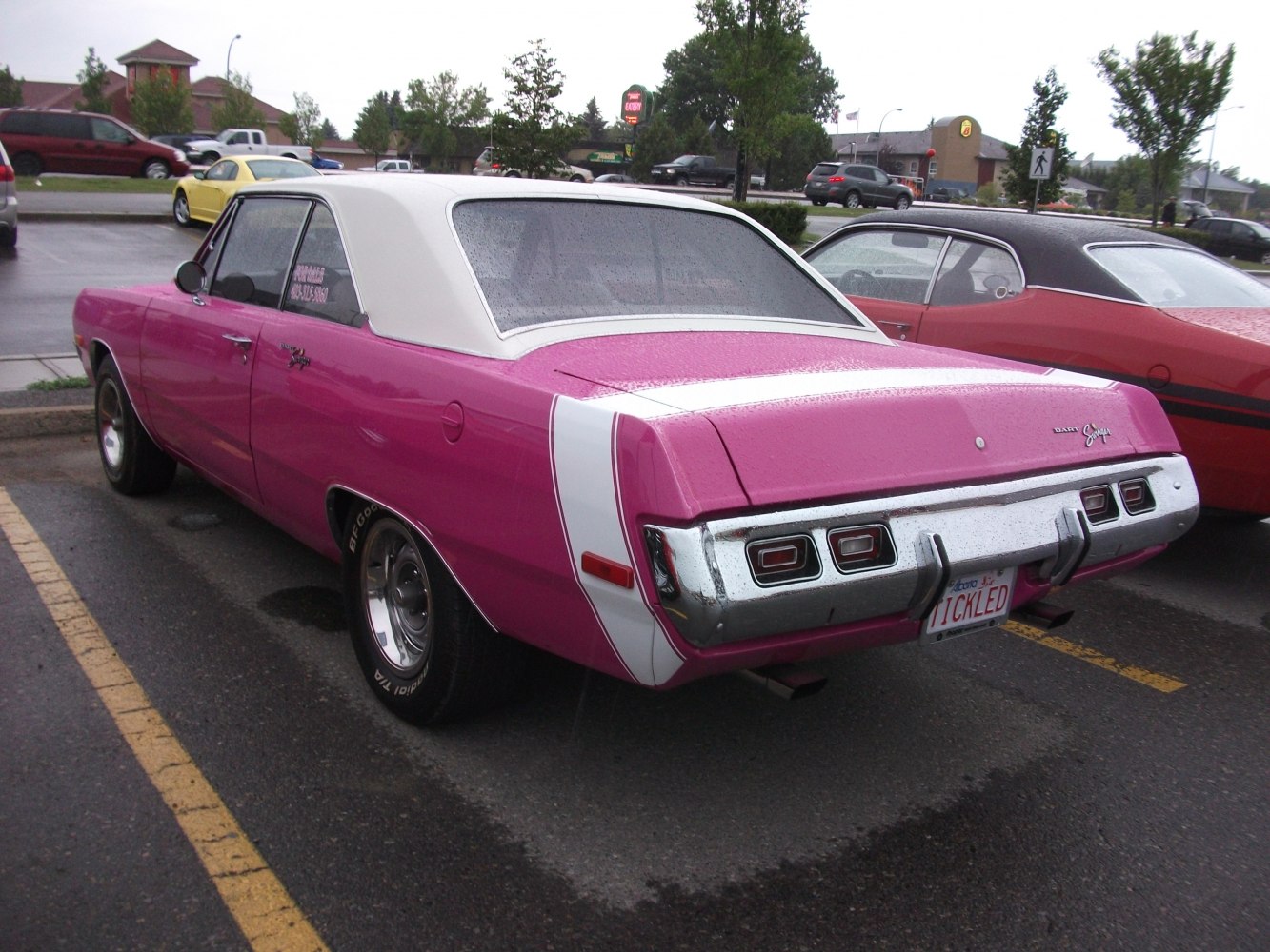 Rear and side view of purple muscle car with white vinyl roof and triple rear lights