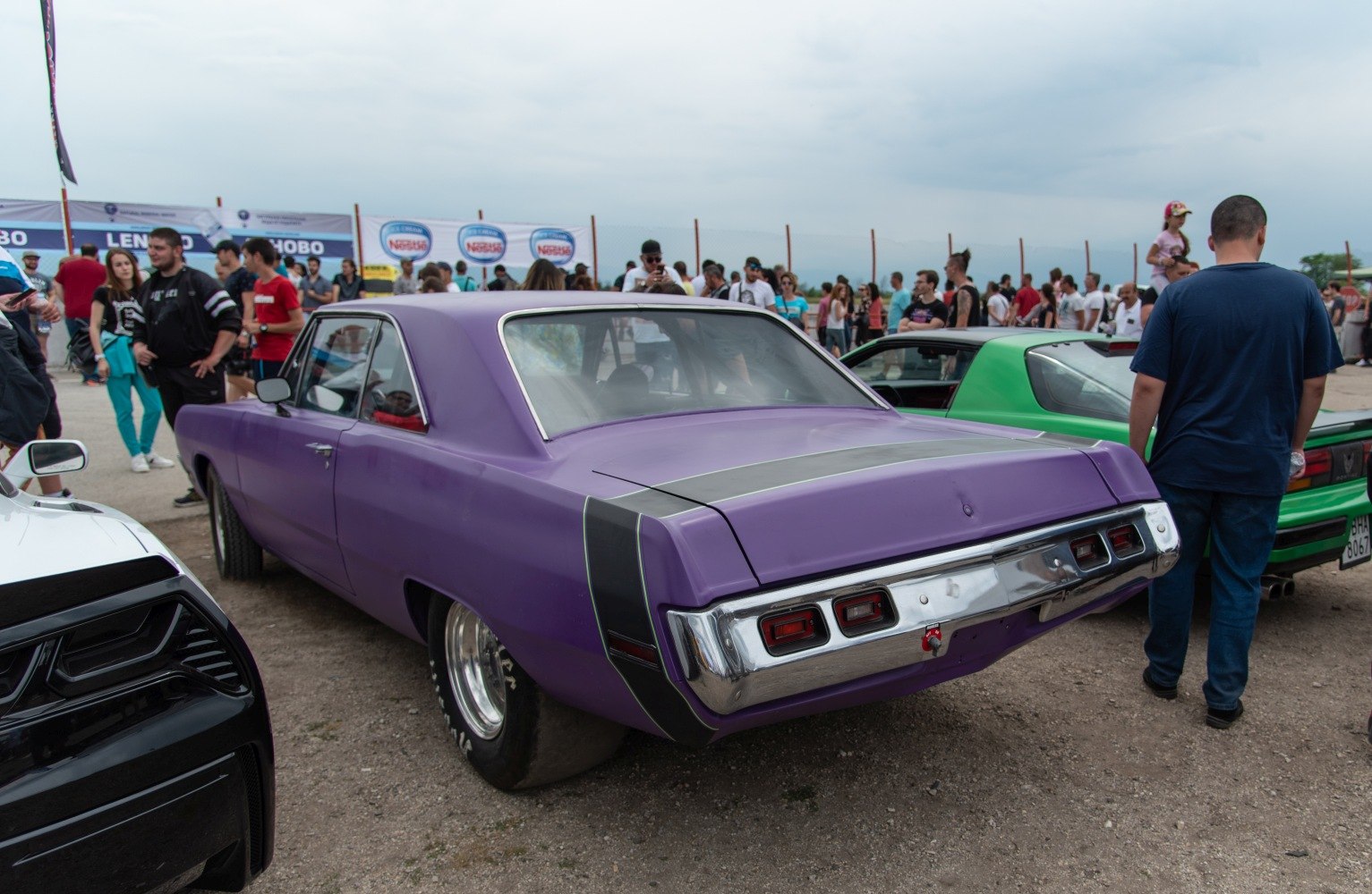 Rear view of classic muscle car with triple tail lights and wide tires