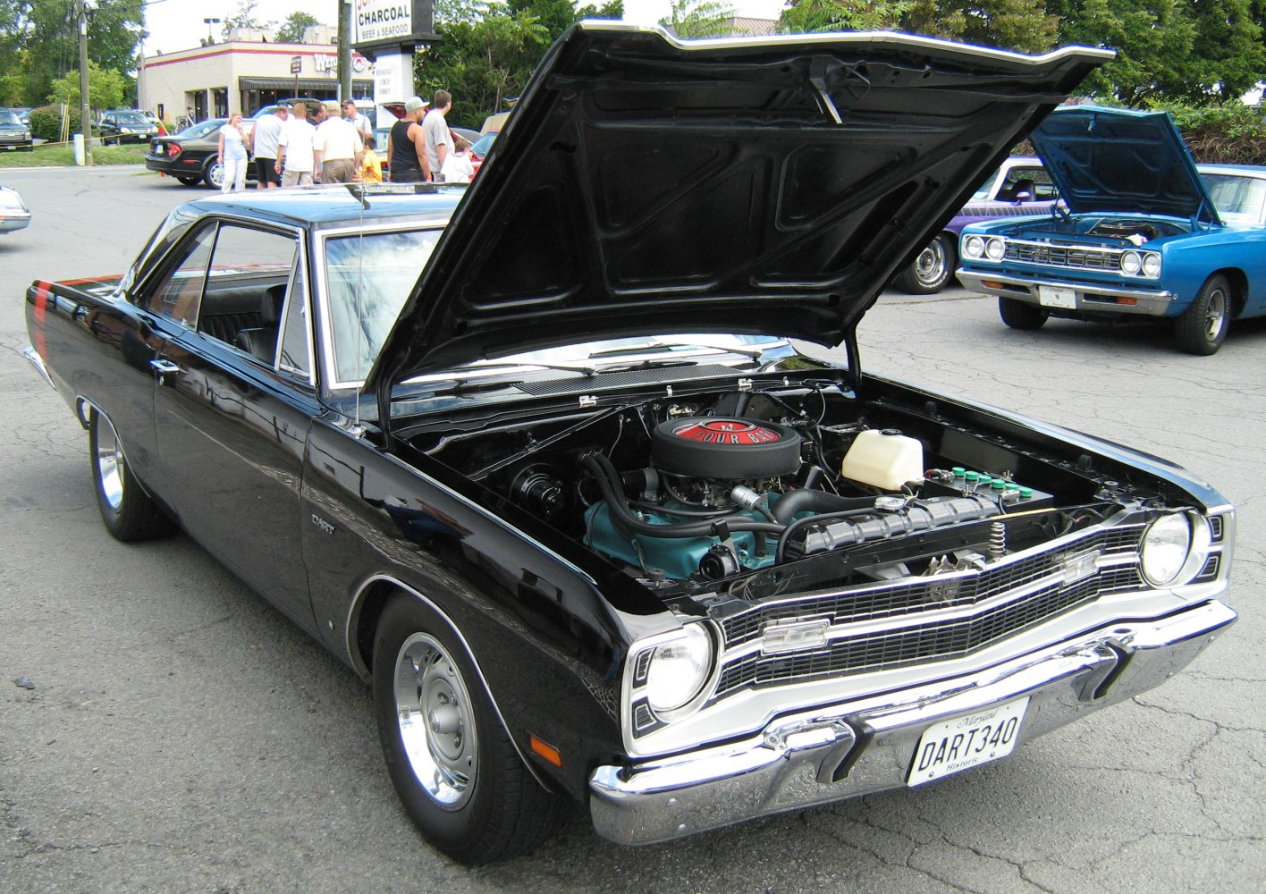 Classic muscle car with open hood displaying engine bay and exterior details