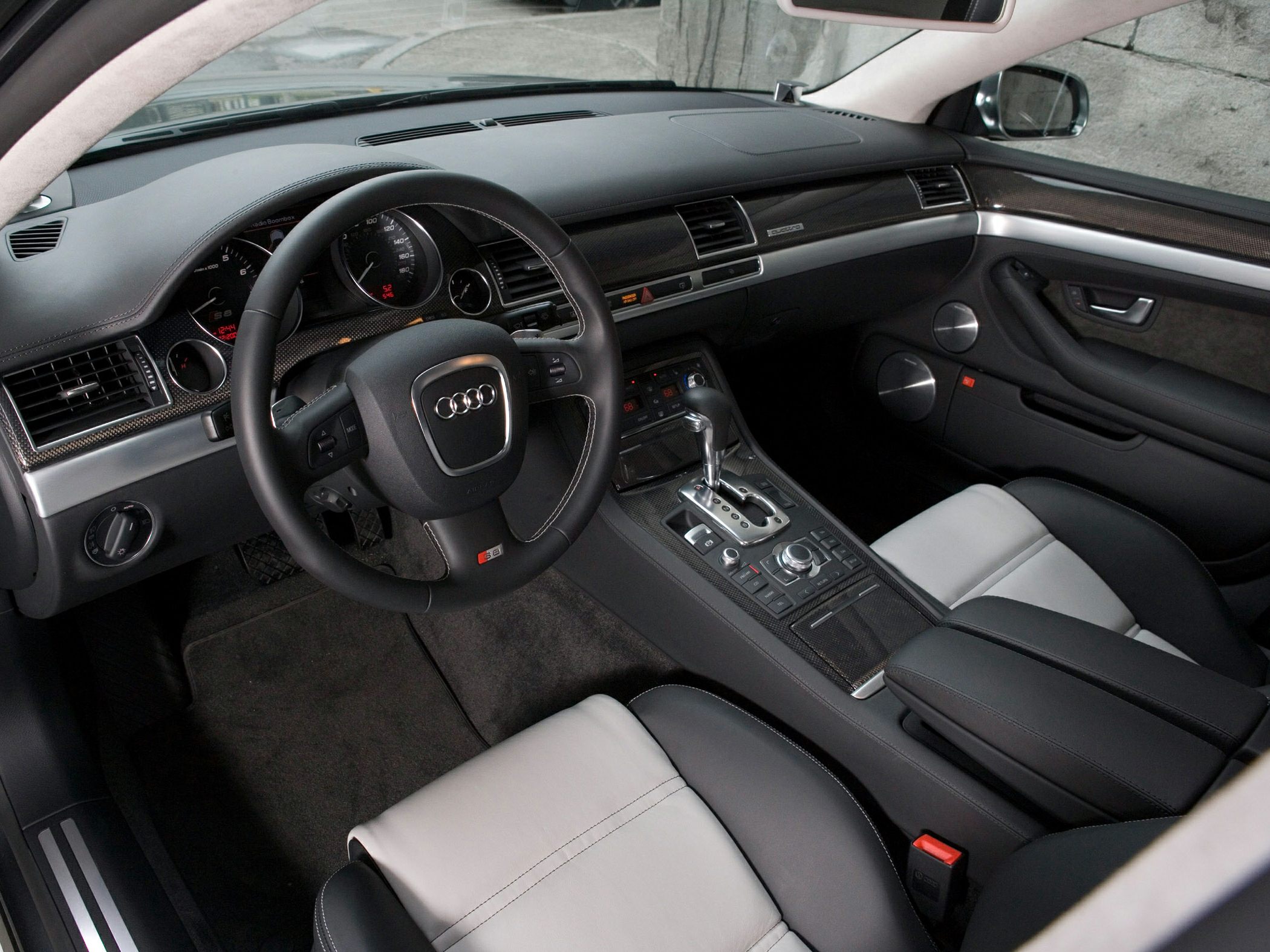 Luxury car interior with leather seats, steering wheel, and dashboard controls.
