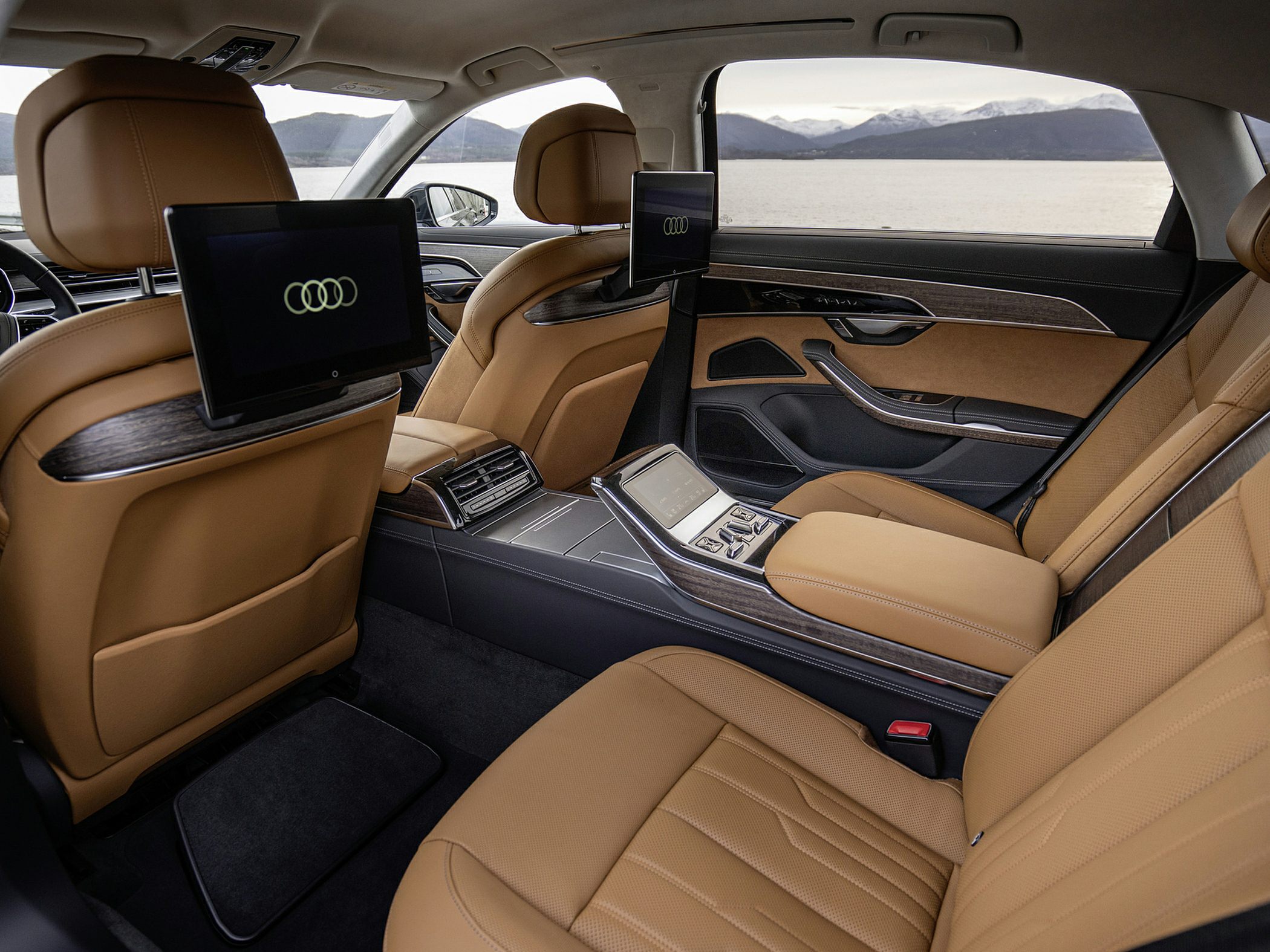 Luxury rear passenger interior with dual screens and central console controls