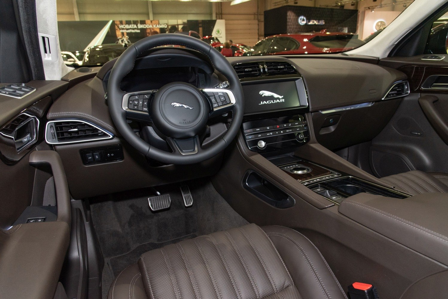 Luxury car interior with leather steering wheel and digital infotainment screen