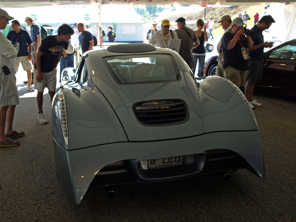 Rear view of a sleek sports car with aerodynamic curves and rear vent