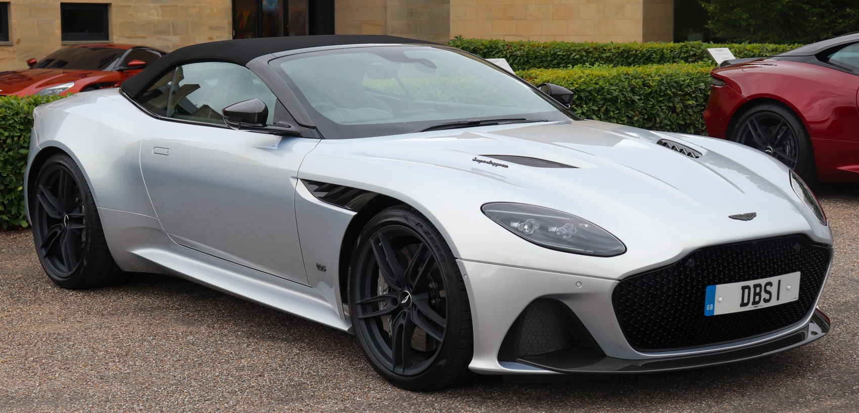 Silver convertible with black soft top and aggressive front grille