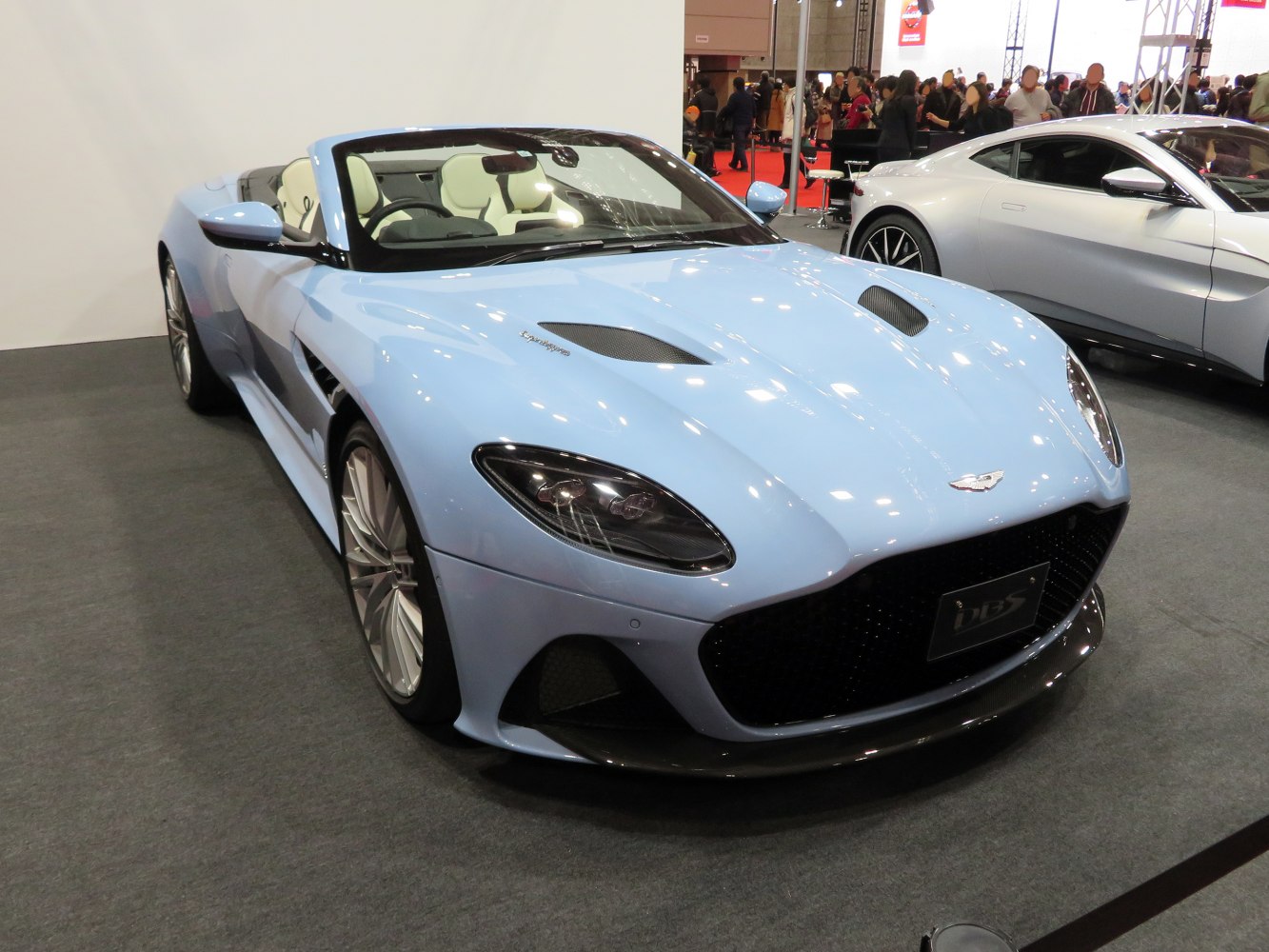 Convertible sports car with aggressive front grille and aerodynamic hood vents