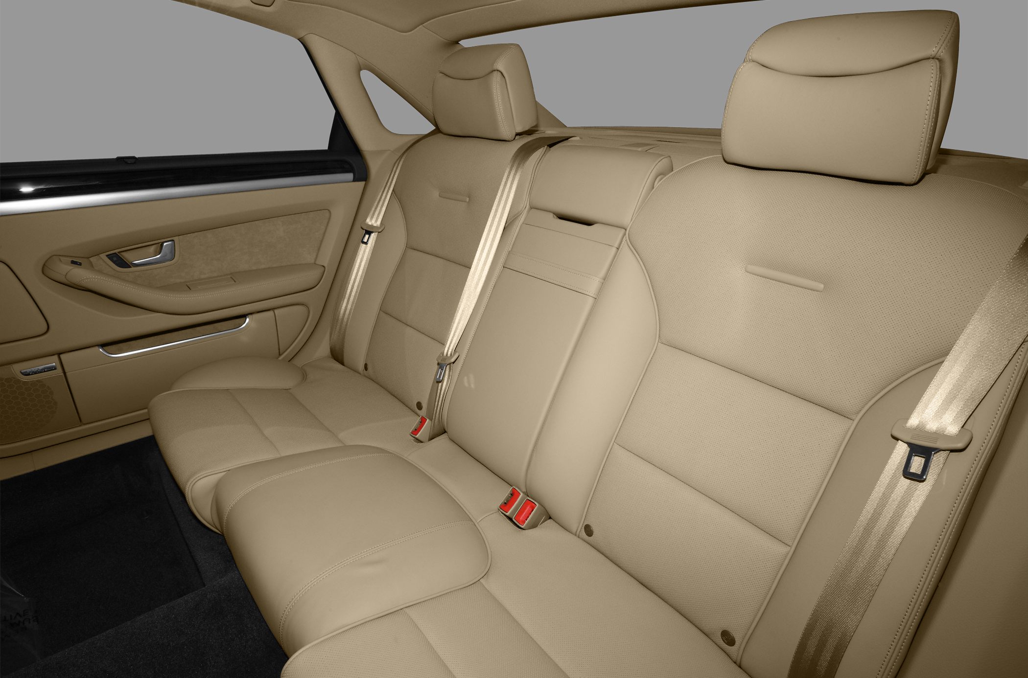 Beige leather rear seat interior with seatbelts and door panel