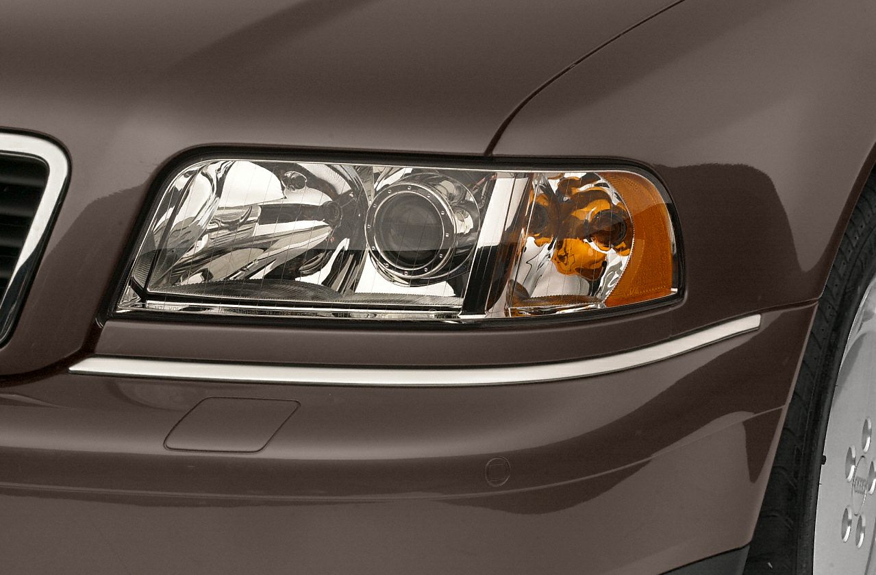 Detailed close-up of a classic headlight and front bumper section