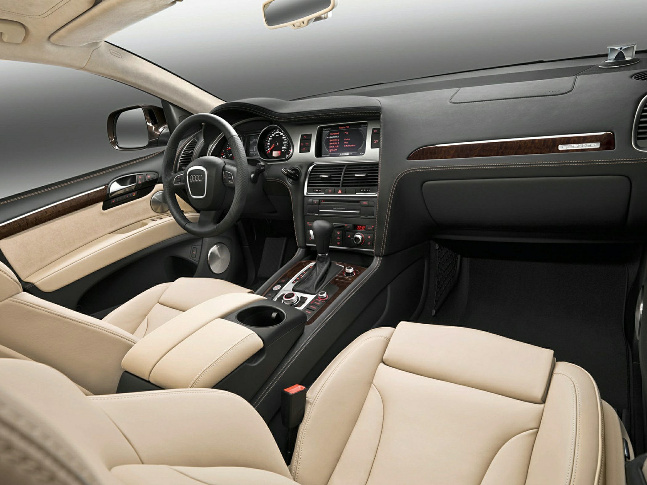 Beige leather seats with a wooden trimmed dashboard and modern control panel