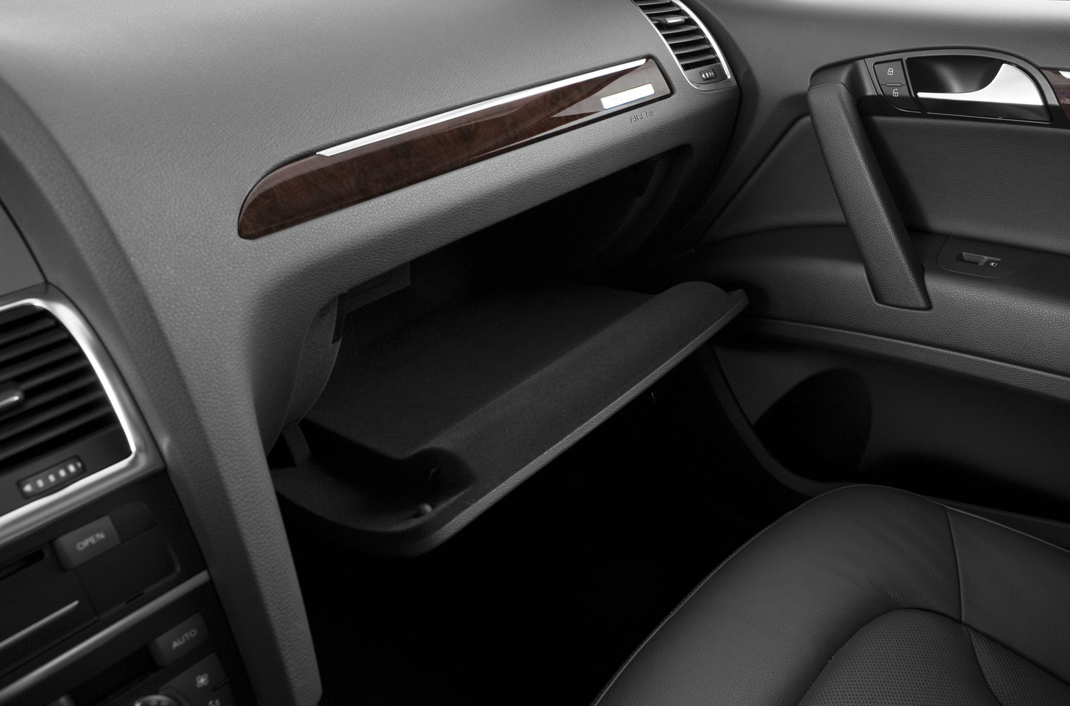 Dashboard and open glove compartment with leather seat and wood trim