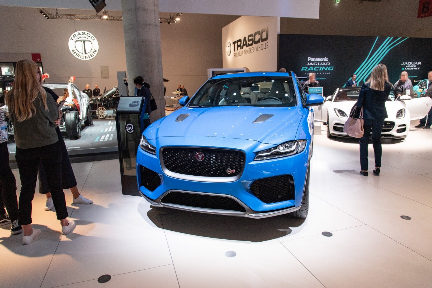 Blue luxury SUV front with sporty grille and hood vents.