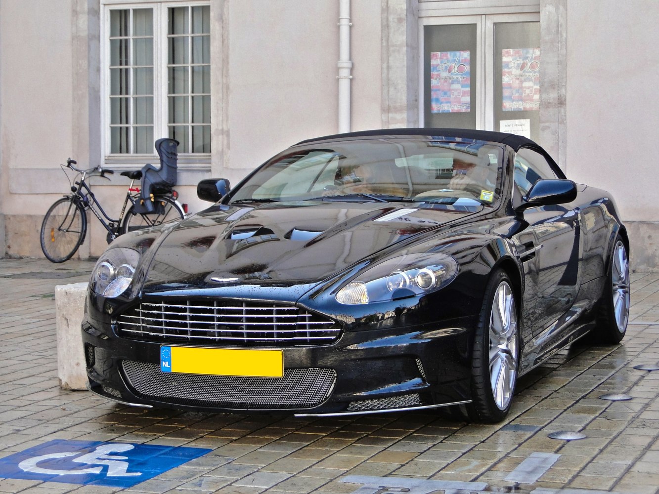 Front view of a black convertible sports car with detailed grille and aerodynamic hood.